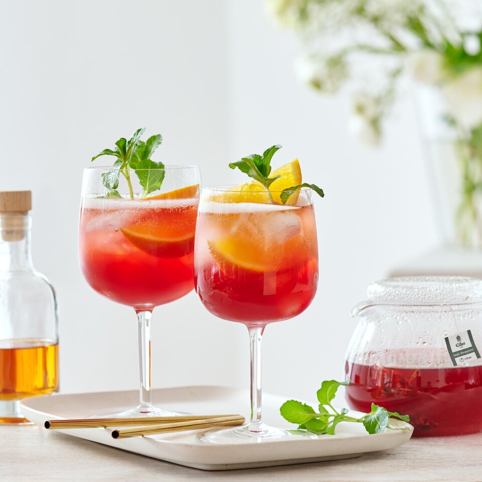 Erfrischende Frühlingscocktails mit Zitrusfrüchten und Minze auf einem Holztisch, perfekt für Veranstaltungen bei warmem Wetter.