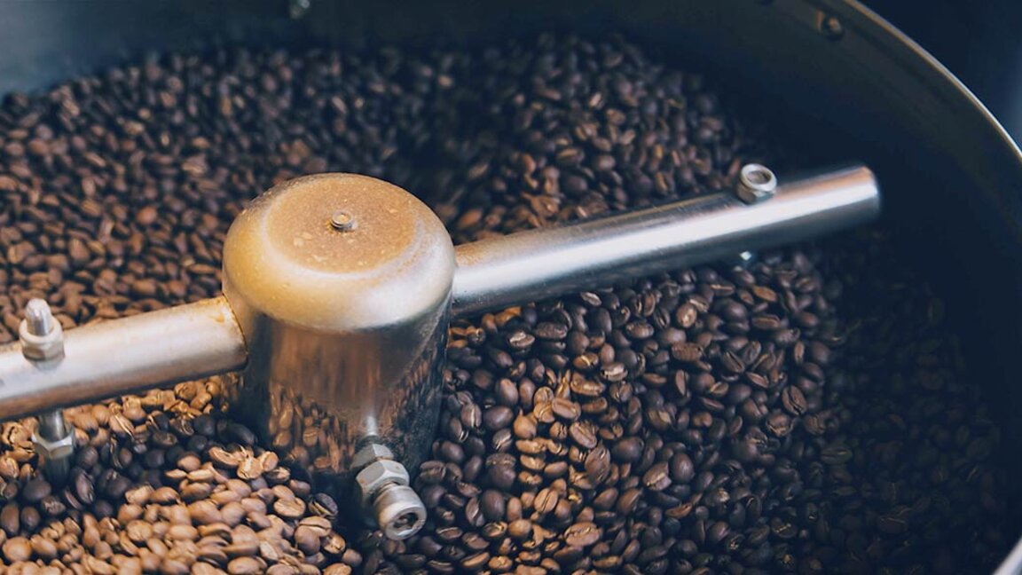 Frisch geröstete Kaffeebohnen kühlen in einer Röstmaschine ab und bringen die reichen Farben und Texturen von Spitzenkaffee zur Geltung.
