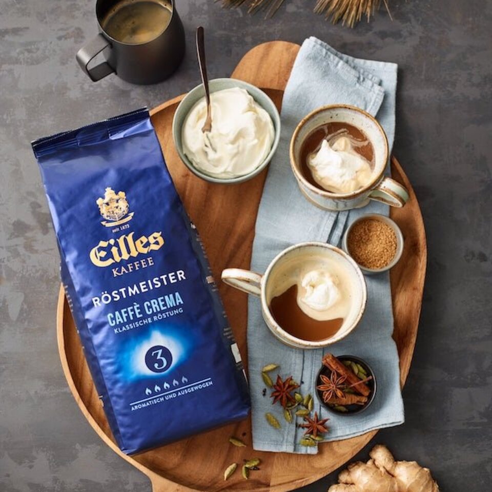 Eilles Röstmeister-Kaffeepaket mit Tassen mit cremigem Kaffee, Zucker und Gewürzen, perfekt für ein wärmendes Getränkeerlebnis.