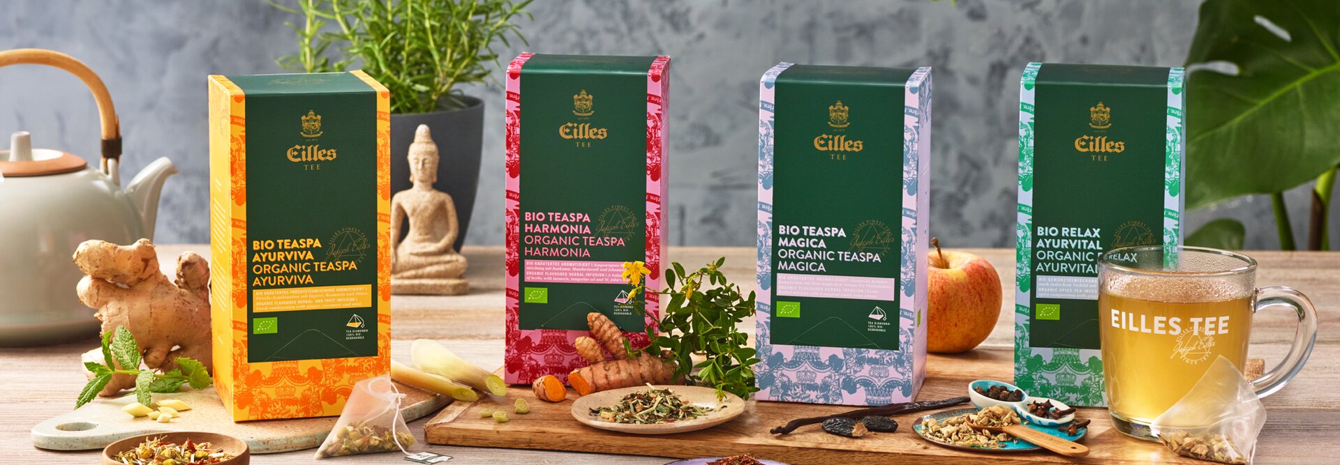 Das Bio-Ayurveda-Teesortiment von Eilles Tea, präsentiert mit frischen Zutaten, einer Teekanne und einer Tasse Tee. Perfekt für Wellness.
