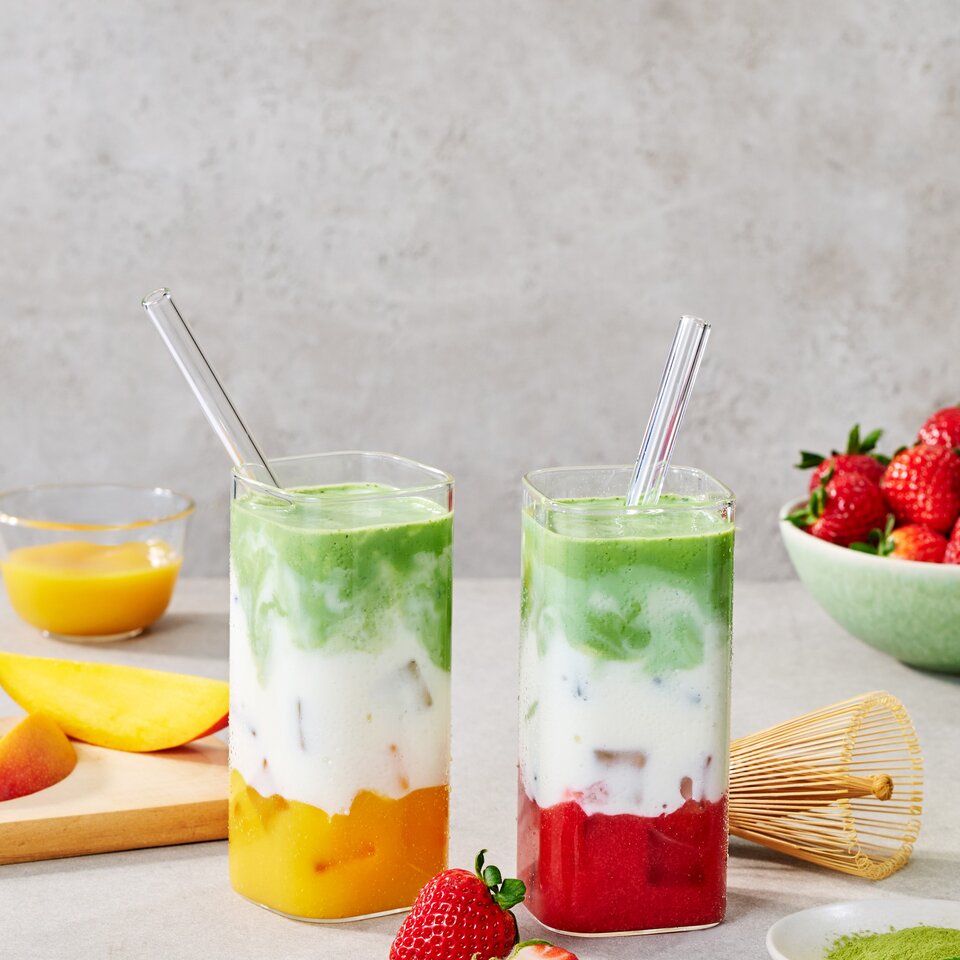 Erfrischender, fruchtiger Matcha-Eis-Latte mit leuchtenden Schichten, ergänzt durch Erdbeeren und Matcha-Pulver. Der perfekte Sommergenuss!