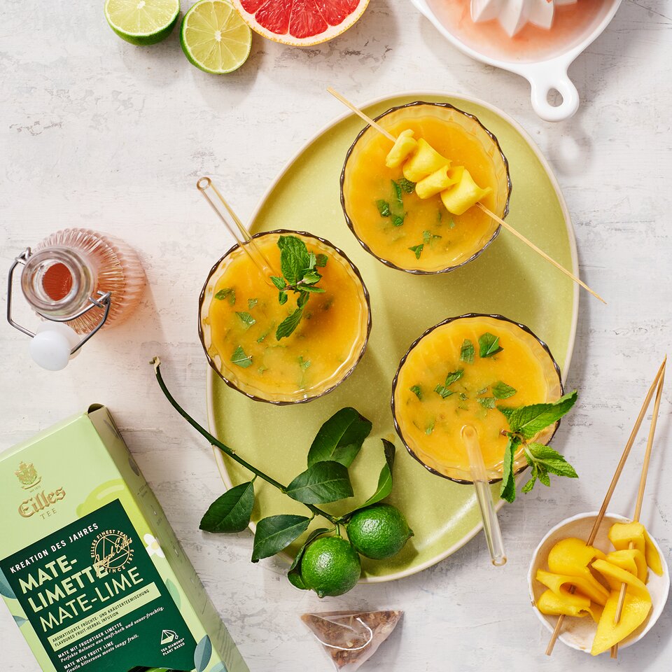 Erfrischender Mate-Limetten-Smoothie mit Mango, Grapefruit und Zitrusfrüchten als Garnierung, perfekt für einen Sommerdrink.