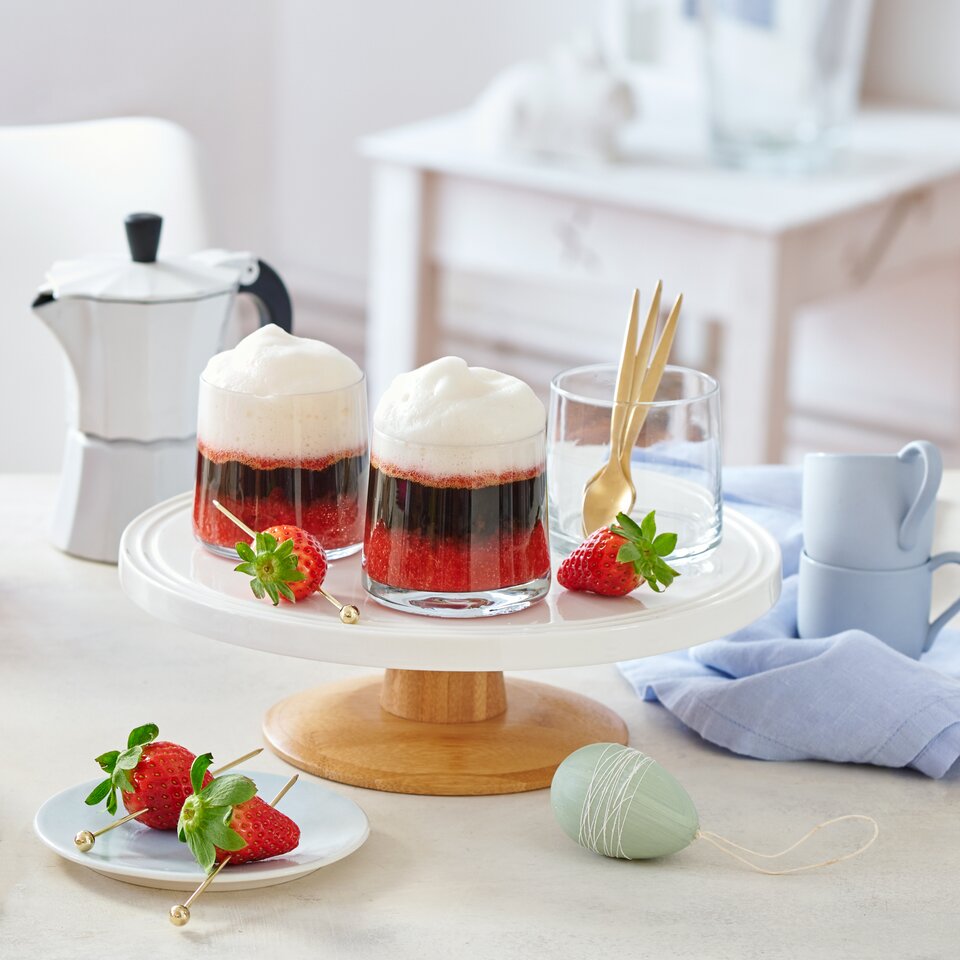 Köstlicher Erdbeer-Espresso, serviert in Glastassen, garniert mit frischen Erdbeeren auf einem stilvollen Kuchenständer.