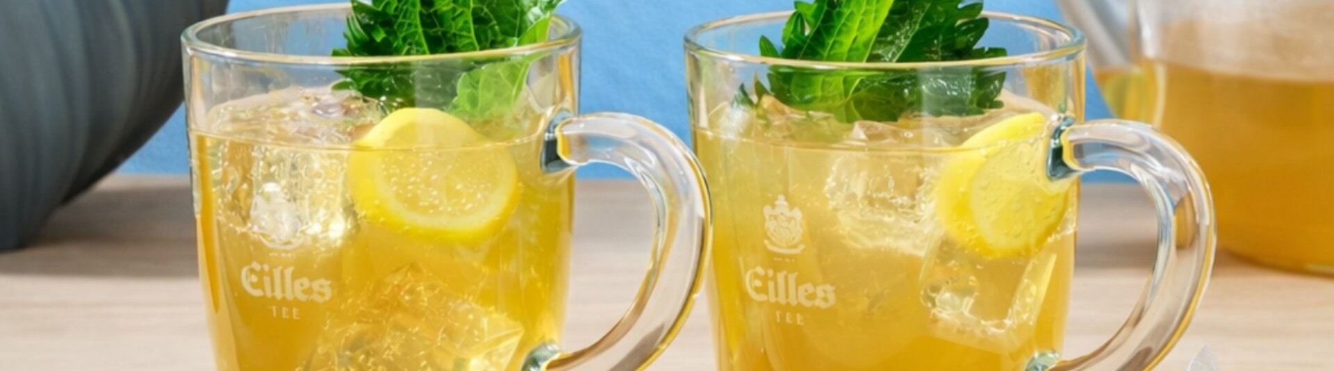 Verfrissende groene thee yuzu ijsthee met gemberbier, gegarneerd met citroen en munt, geserveerd in glazen mokken.