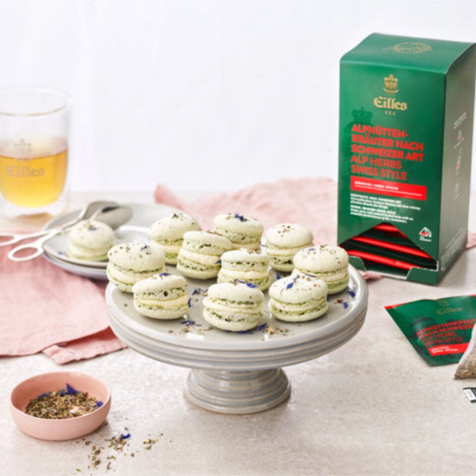 Köstliche Makronen im Ständer serviert, gepaart mit Eilles-Tee und Kräutern für ein köstliches Erlebnis. Perfekt für Teeliebhaber.