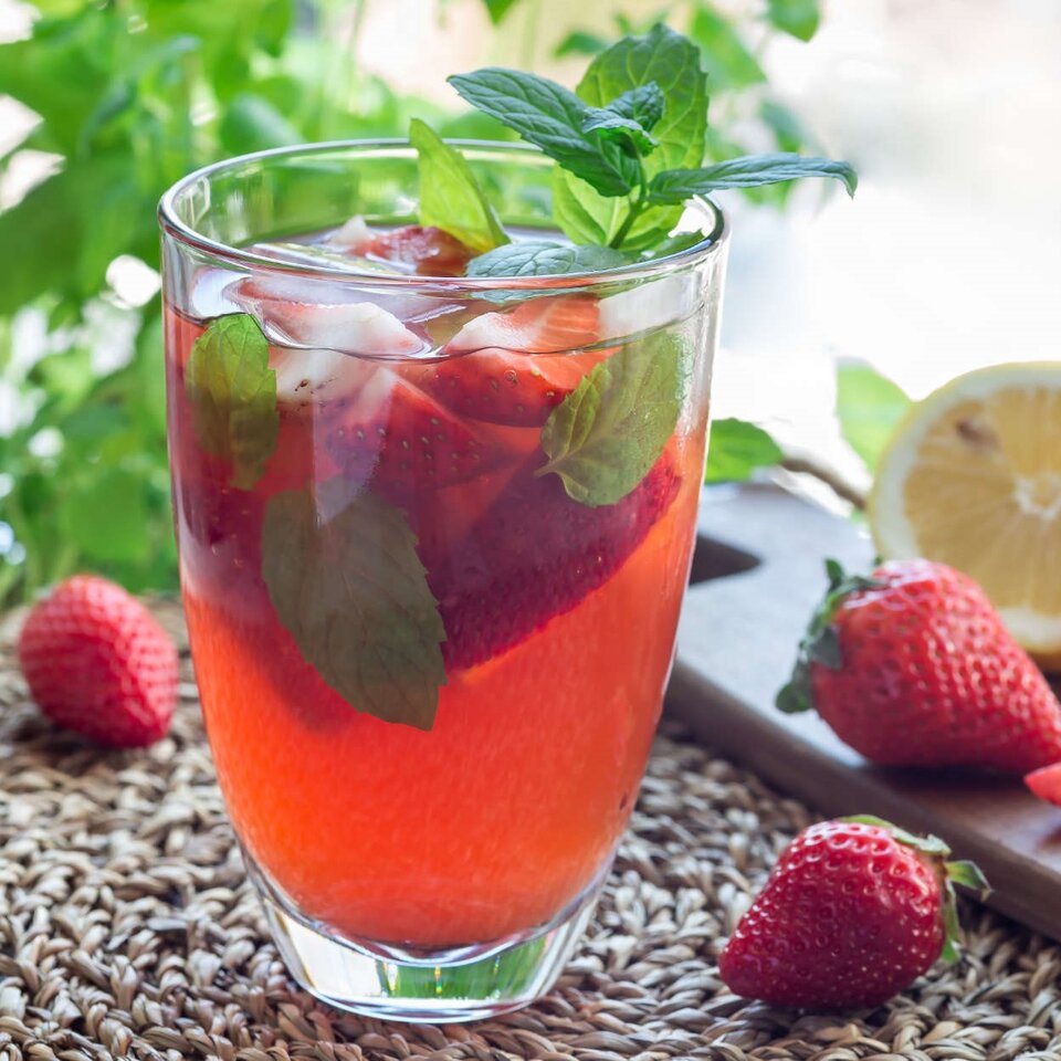 Erfrischender Sommerbeeren-Eistee mit Erdbeeren und frischer Minze, perfekt für warme Tage.