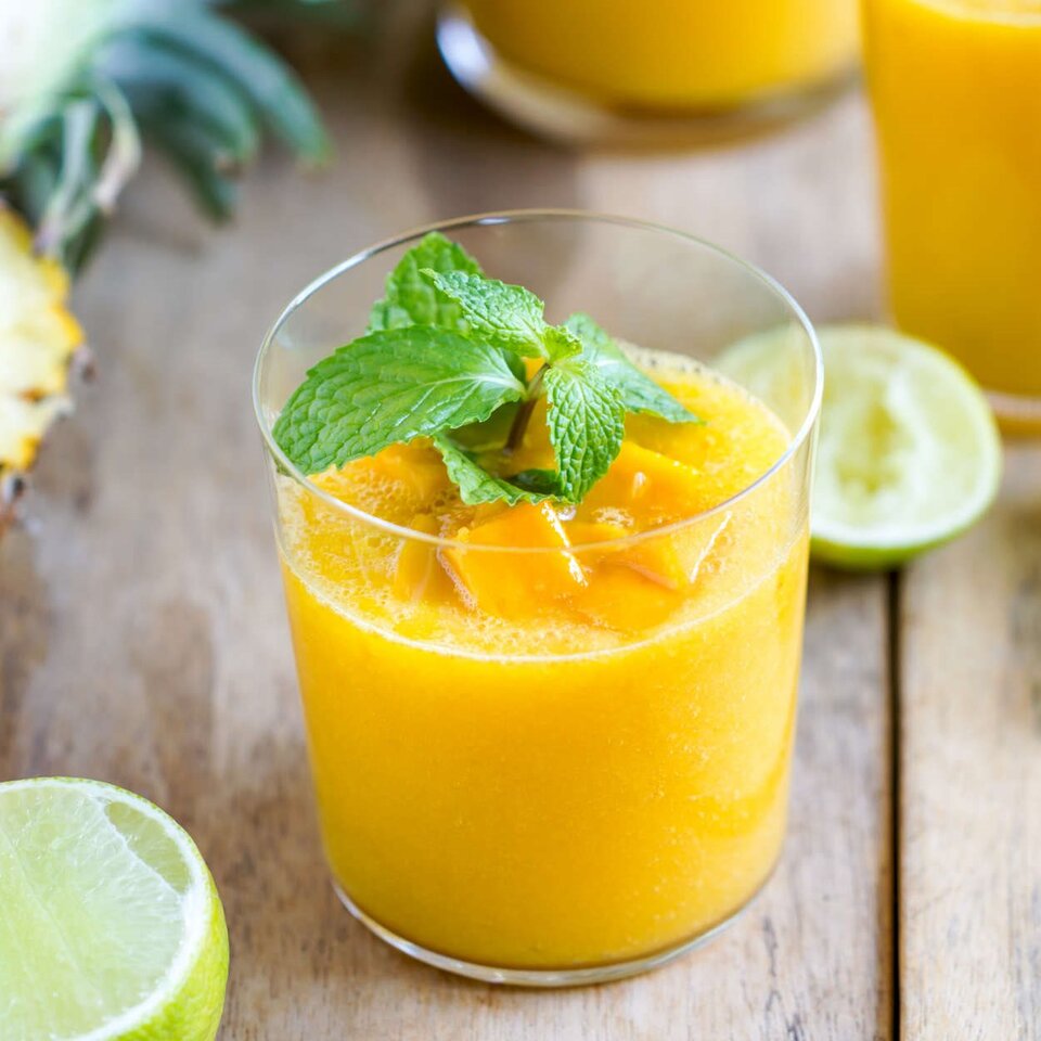 Erfrischender Eistee aus Mango und Orange mit frischer Minze, perfekt für ein Sommergetränk.