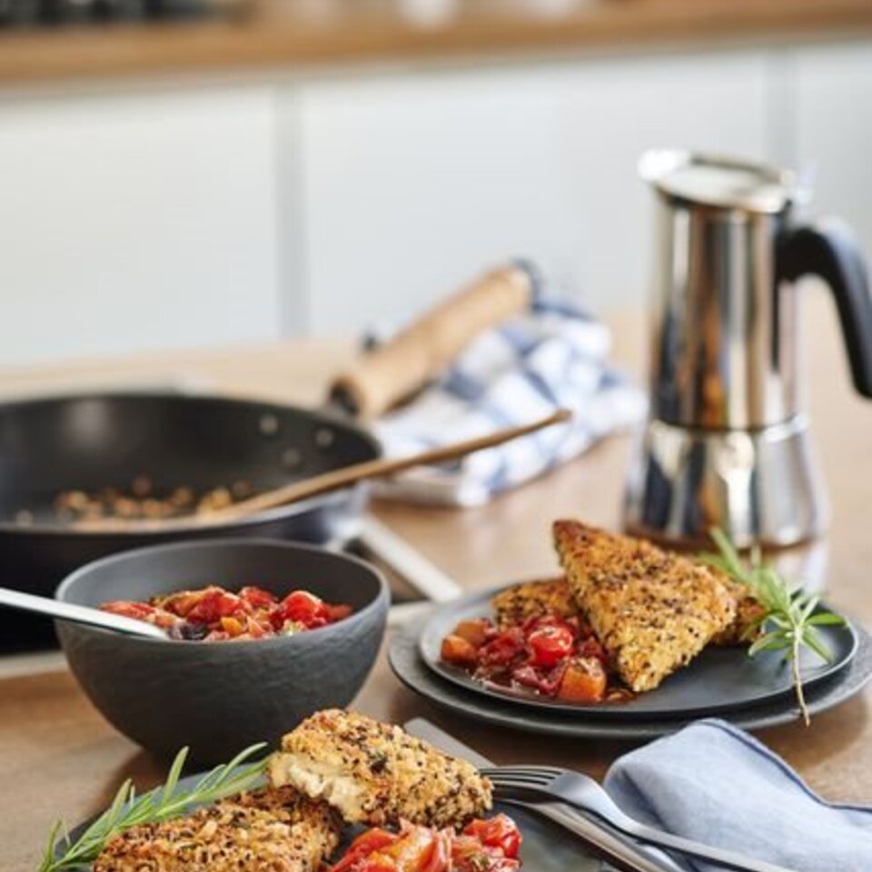 Knuspriger Schafskäse, serviert mit gerösteten Tomaten, dazu eine Kaffeekanne, perfekt für einen leckeren Brunch.