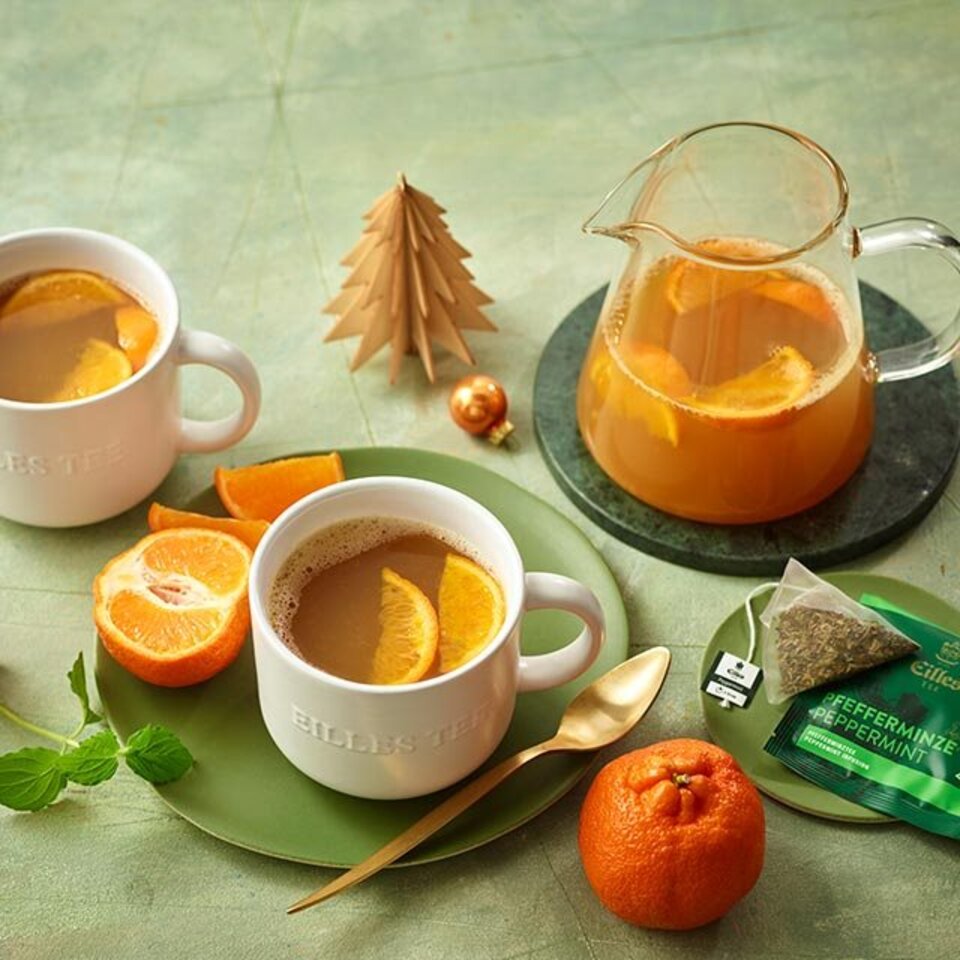 Warmer Minz- und Mandarinenpunsch, serviert in eleganten Tassen, perfekt für gemütliche Zusammenkünfte und festliche Anlässe.