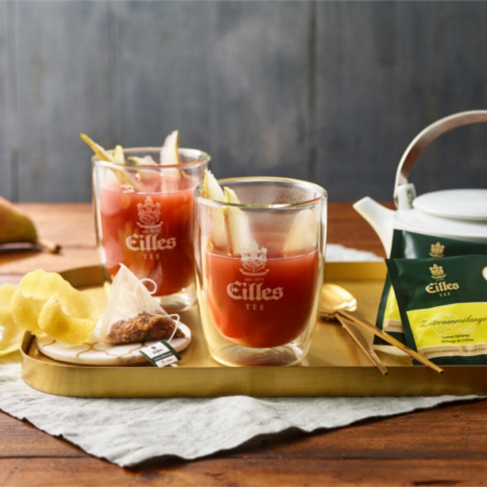 Erfrischender Eilles-Tee mit Zitrone und Birne, serviert in Gläsern auf einem stilvollen Tablett, perfekt für Teeliebhaber.