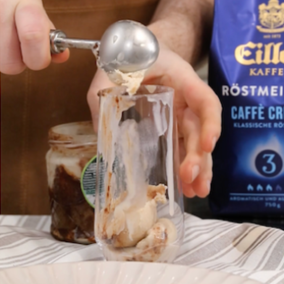 Es wird ein nussiger Nougat-Eiskaffee serviert, der mit Kugeln aus Eis und einer reichhaltigen Kaffeemischung zu einem köstlichen Genuss wird.