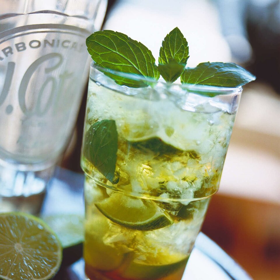 Erfrischender Cocktail mit Minze und Limette, auf Eis serviert, perfekt für sommerliche Zusammenkünfte.
